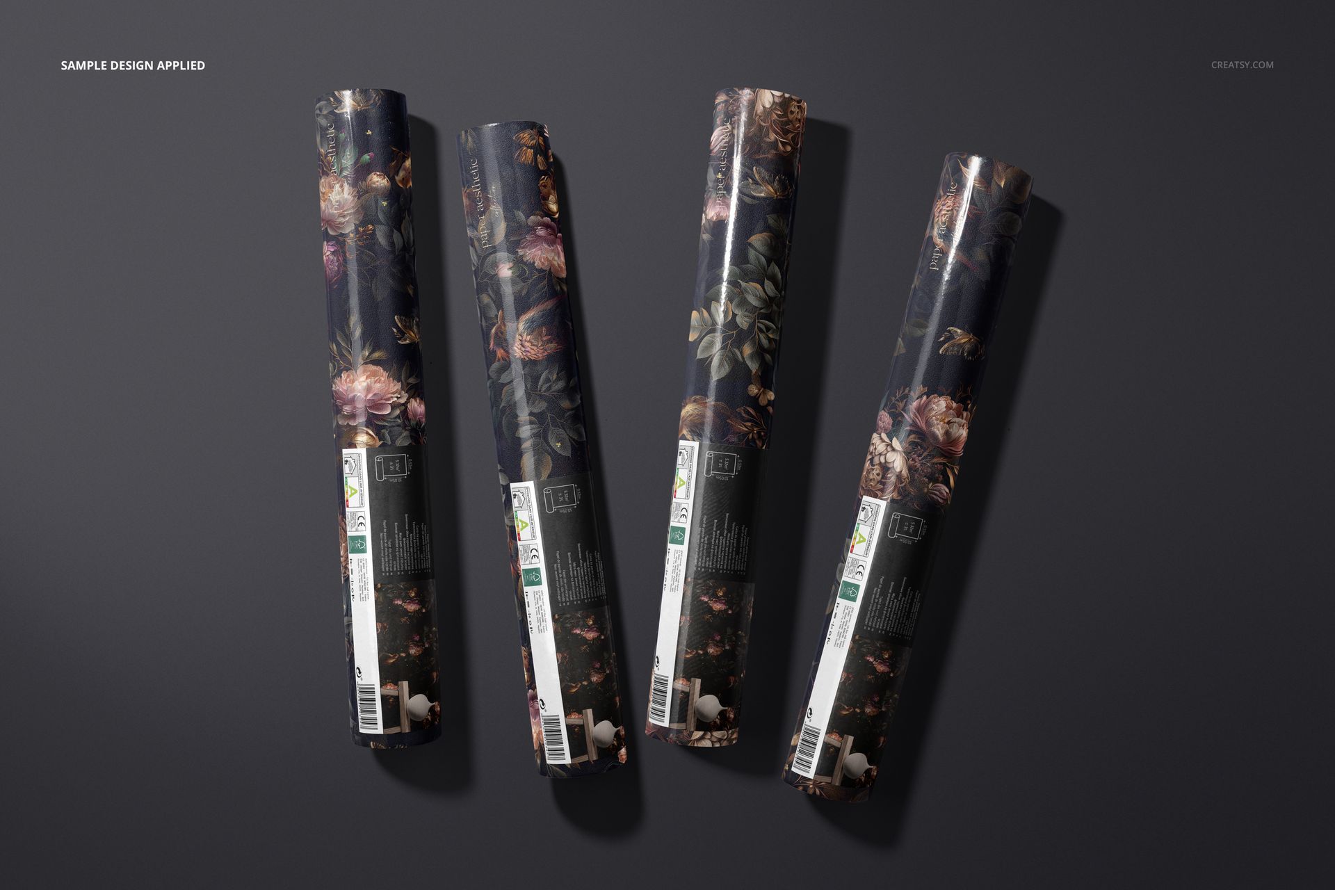 Rolled wallpaper mockup featuring a non-woven vinyl material with intricate floral designs on a dark background.