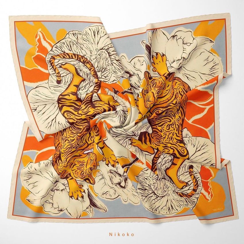 Twill silk scarf mockup featuring an intricate pattern of dancing tigers and large floral elements in orange, beige, and gray tones.