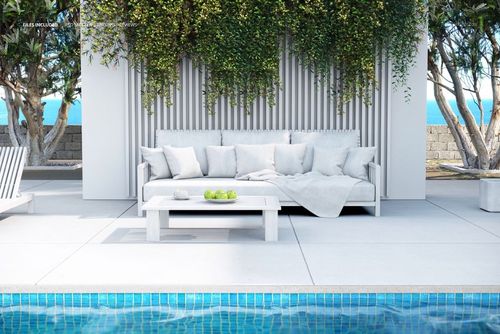 Modern outdoor sofa mockup featuring neutral cushions and throw blanket, placed by a pool with lush plants overhead.