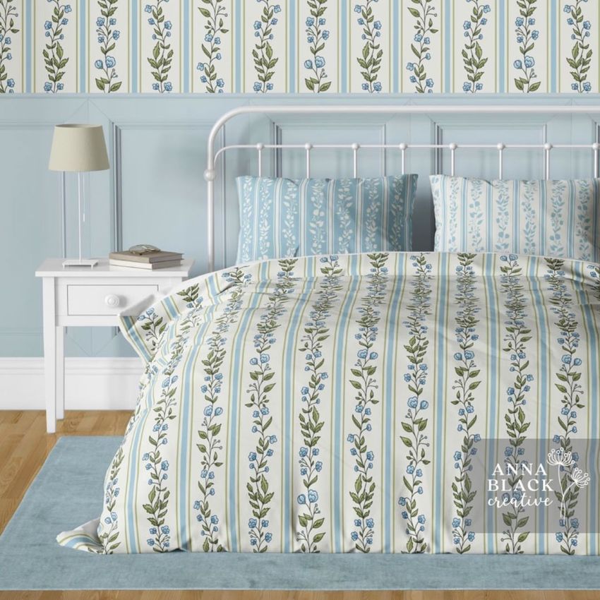 Vintage bedroom bedding mockup showing a metal bed with floral patterned duvet and pillows in blue and green tones.