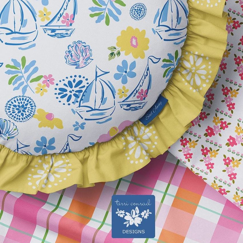 Ruffled pillow mockup featuring a round cushion with blue sailboat and floral patterns, yellow ruffle trim, and colorful fabric props.