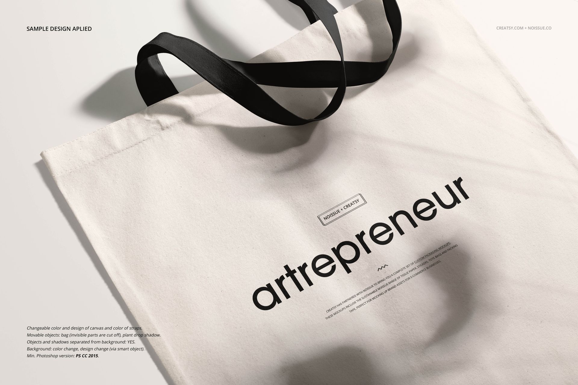Close-up of a white tote bag mockup with black straps and minimalist text, shown on a neutral background.