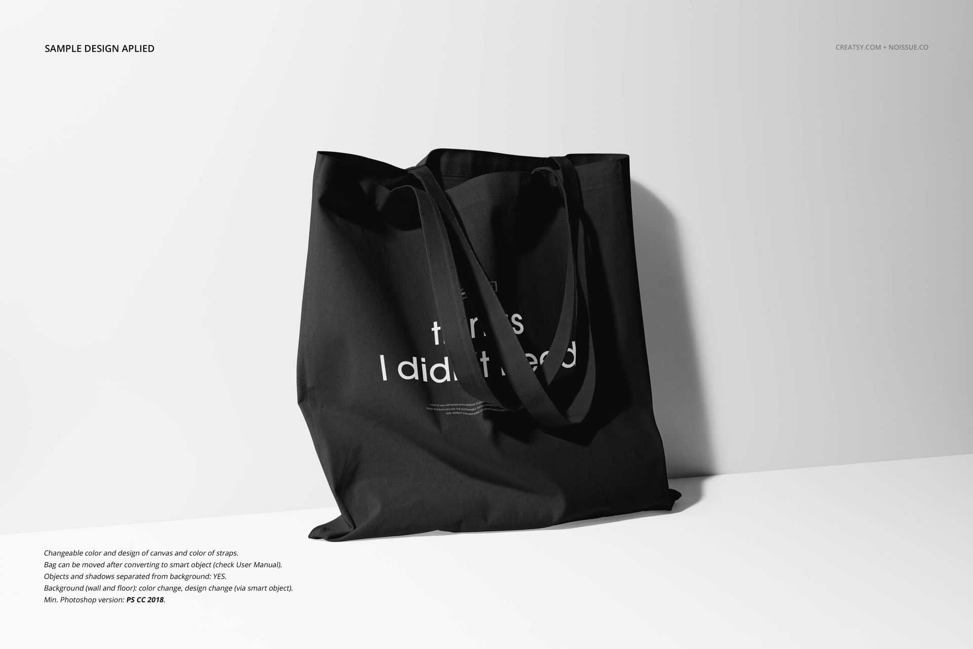 Front-facing black tote bag mockup with subtle shadow, featuring white lettering and a plain background.