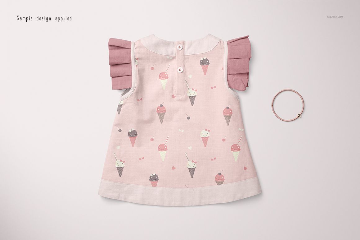Front view of a baby blouse mockup with pink ice cream cone pattern, pink pleated sleeves, and a bracelet on a light background.