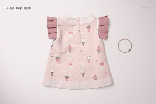 Front view of a baby blouse mockup with pink ice cream cone pattern, pink pleated sleeves, and a bracelet on a light background.