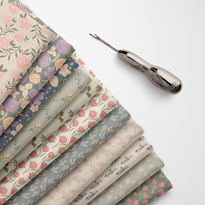 Folded fabrics mockup showing several patterned fabric swatches in pastel colors, arranged in a fan shape on a white surface.