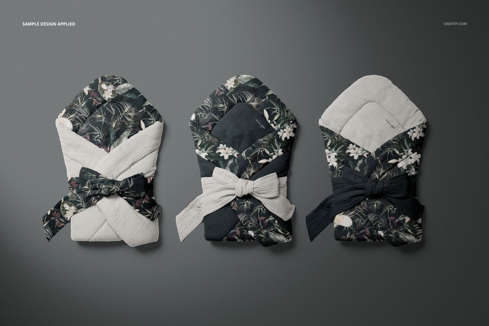 Muslin baby wrap mockup set showing three wraps with botanical and plain designs, viewed from above on a gray background.