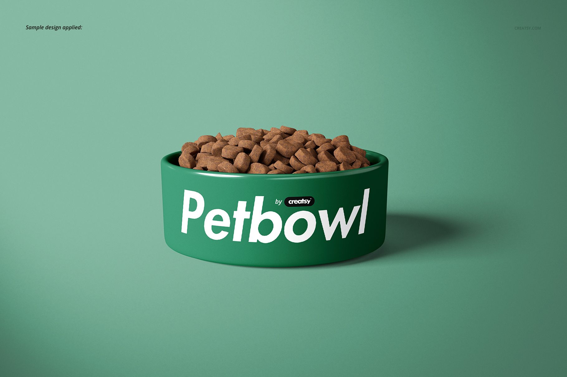 Front-facing green pet bowl mockup with white lettering, filled with brown pet food, set against a mint green backdrop.