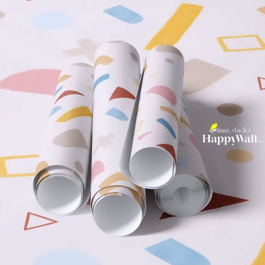 Paper wallpaper mockup featuring four rolled sheets with abstract colorful shapes on a white background, viewed from above.