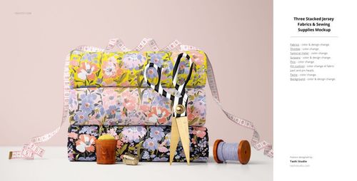 PSD mockup showing layered jersey fabrics with vibrant flower prints, accompanied by pins, scissors, and assorted sewing tools.