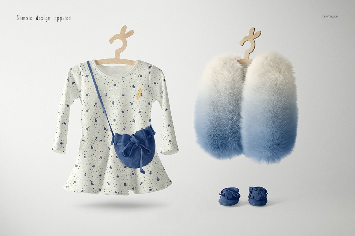 Front view of a baby dress mockup set with a white dress featuring blue star patterns, blue bag, fluffy gradient vest, and matching shoes on a light background.
