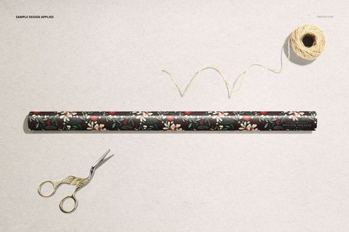 Floral patterned wrapping paper mockup roll on a beige background, shown with scissors and a spool of string.
