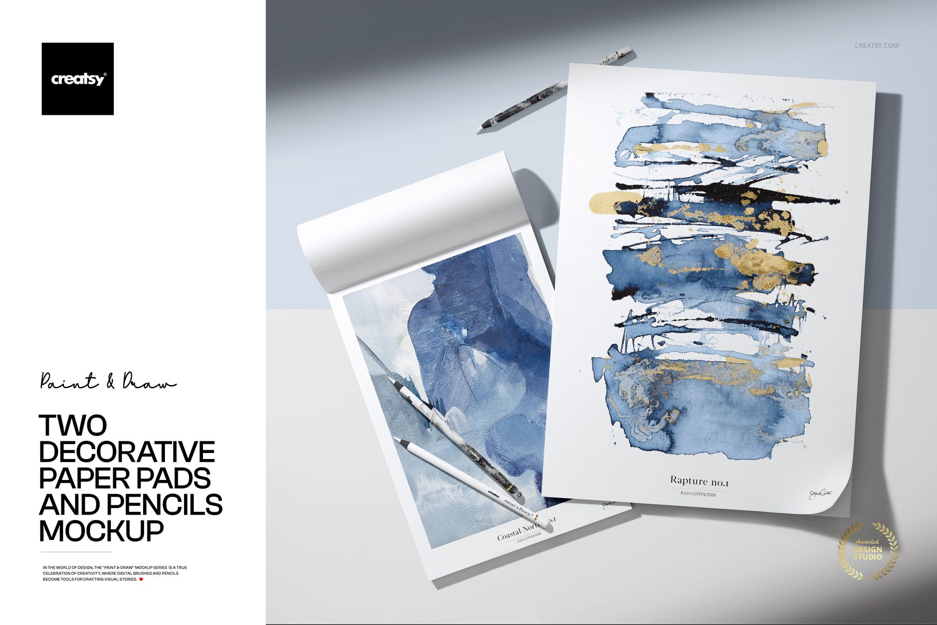 PSD mockup showing two drawing pads with abstract paintings and pencils arranged on a pale background.