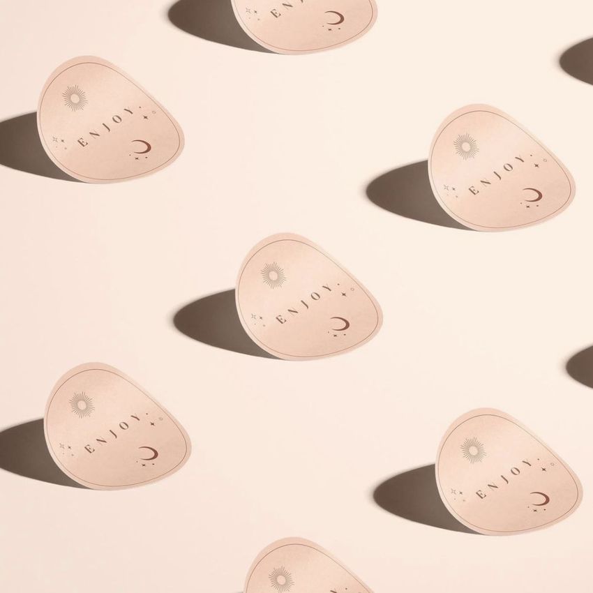 Sticker mockup featuring multiple rounded stickers with minimalist patterns and text on a light beige background with shadows.