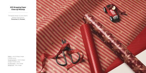 Christmas-themed gift wrapping paper mockup featuring red and gold patterns, scissors, ribbon, and a toy car in a close-up view.