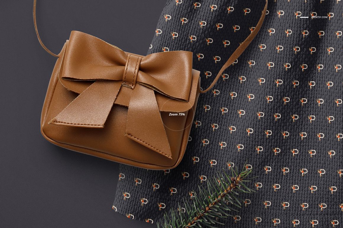 Front view of a baby dress mockup with a repeating small pattern, shown next to a brown purse with a bow detail.