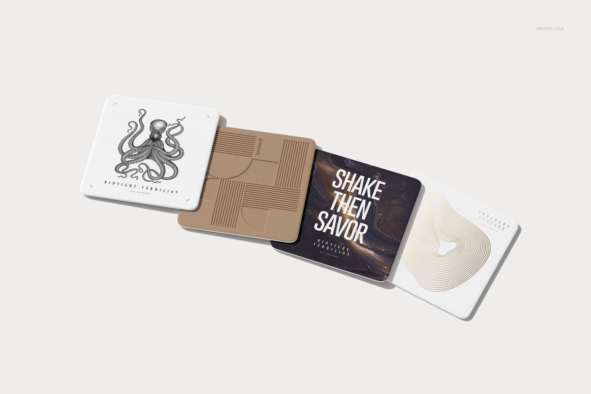 Top view of four square coasters with different patterns and text, displayed on a light surface in a mockup scene.