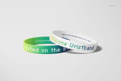 Mockup of two silicone wristbands with pixelated lettering, arranged side by side on a smooth, pale backdrop.