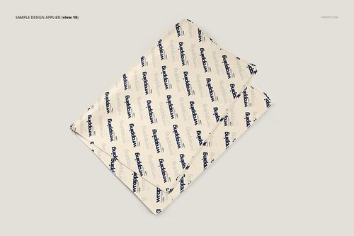 Top view of layered wrapping tissue paper mockup with diagonal blue text design on a neutral surface.