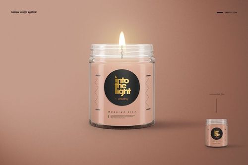 PSD mockup of a glass jar candle featuring a burning wick, beige wax, and dark round label, set against a brown backdrop.