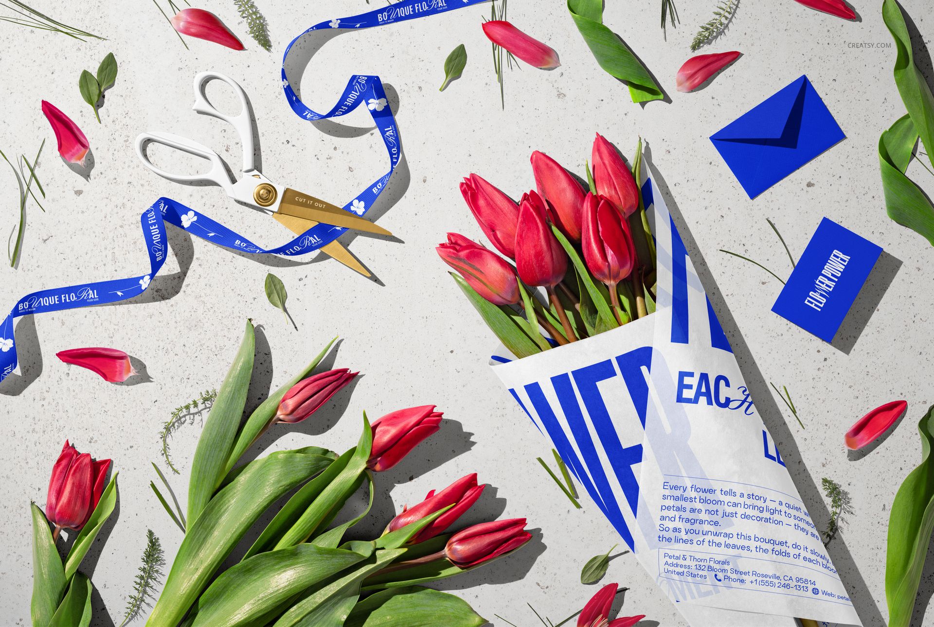 PSD mockup featuring a tulip bouquet in tissue paper, measuring tape, scissors, and scattered floral props on a textured background.