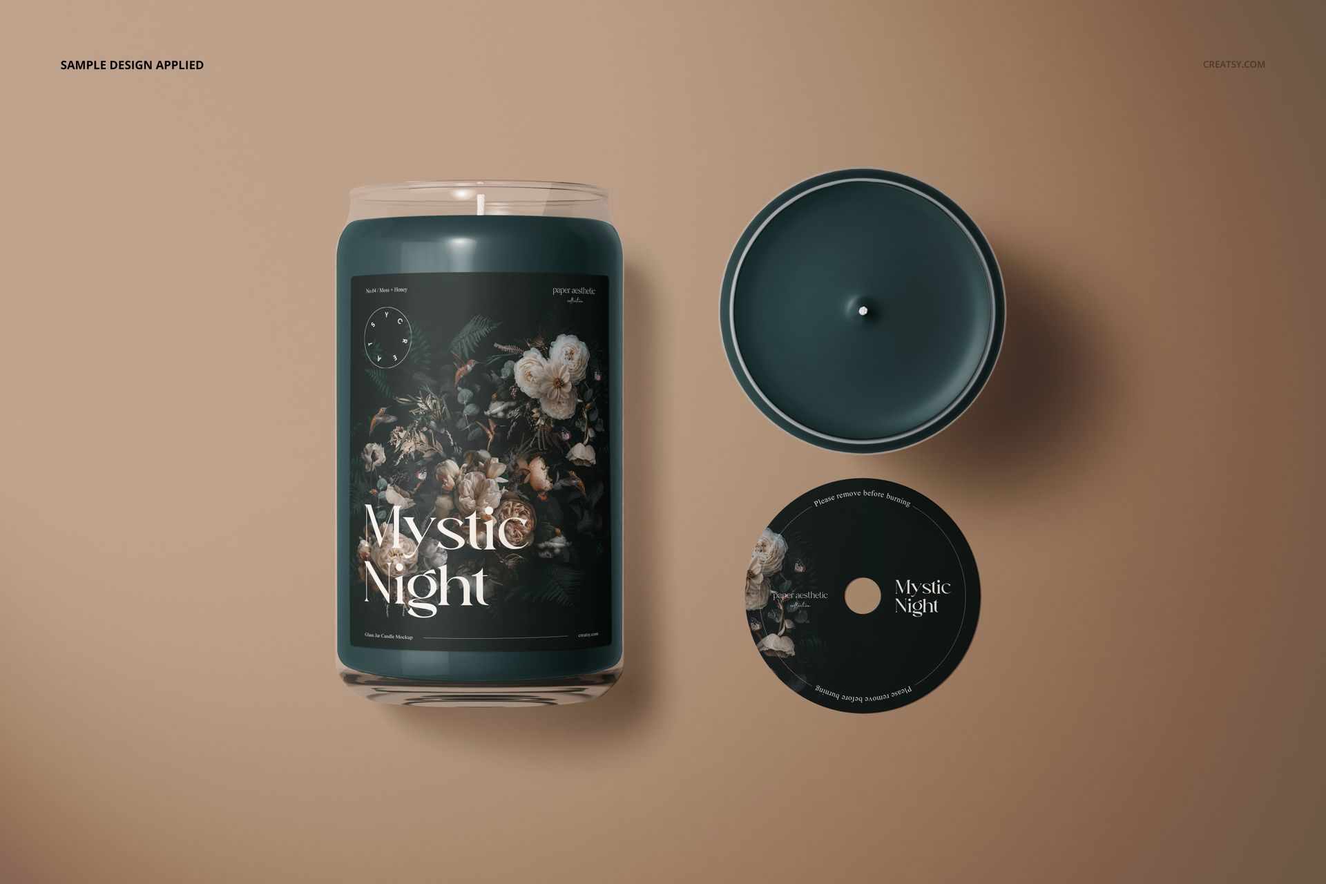 Glass candle mockup set showing a cylindrical candle with floral artwork, lid, and top view on a neutral surface.