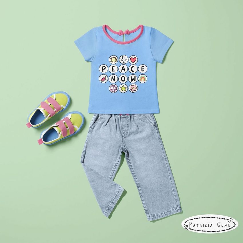 Kids t-shirt and jeans mockup featuring a blue shirt with colorful graphic text, paired with light denim pants and pastel sandals on a green background.