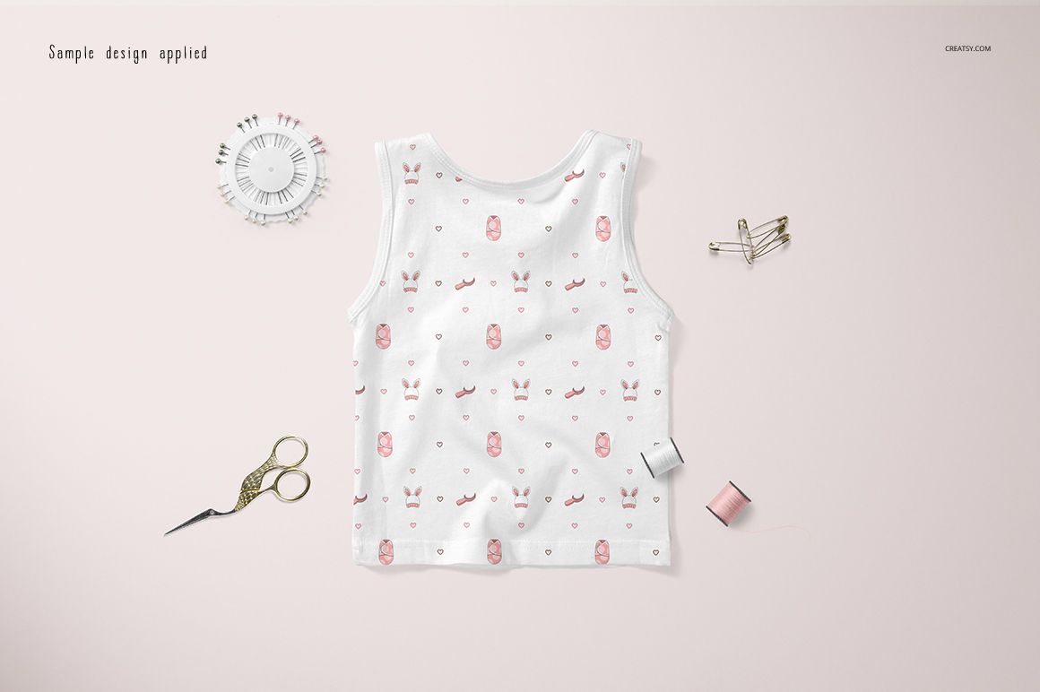 Baby tank top mockup shown from above, featuring a white fabric with small pink owl motifs, surrounded by sewing accessories.