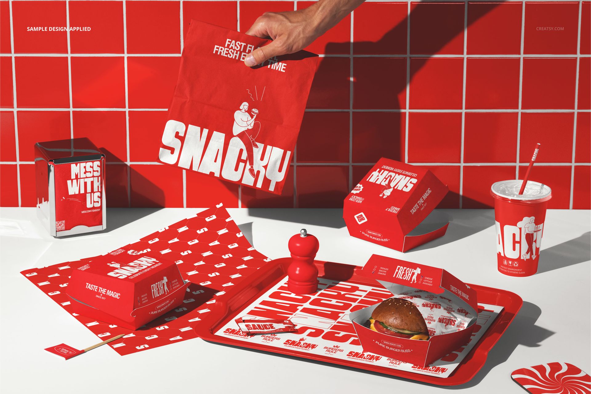 Burger packaging set mockup featuring red branded boxes, wrappers, cup, and tray on a countertop with tiled background.