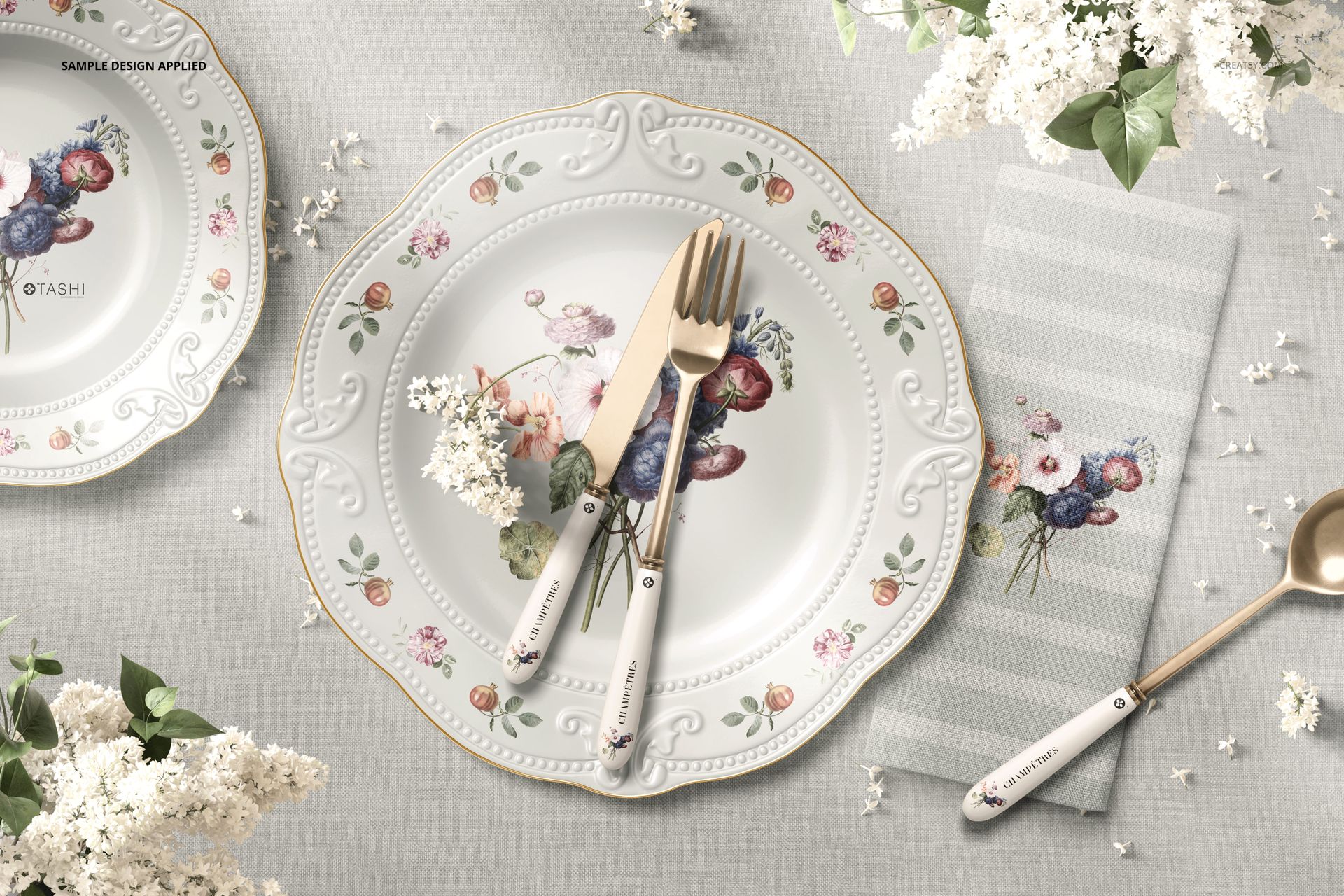 PSD mockup showing a home dining scene with ornate plate, striped napkin, and delicate floral accents from above.
