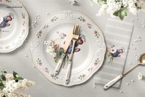 PSD mockup showing a home dining scene with ornate plate, striped napkin, and delicate floral accents from above.