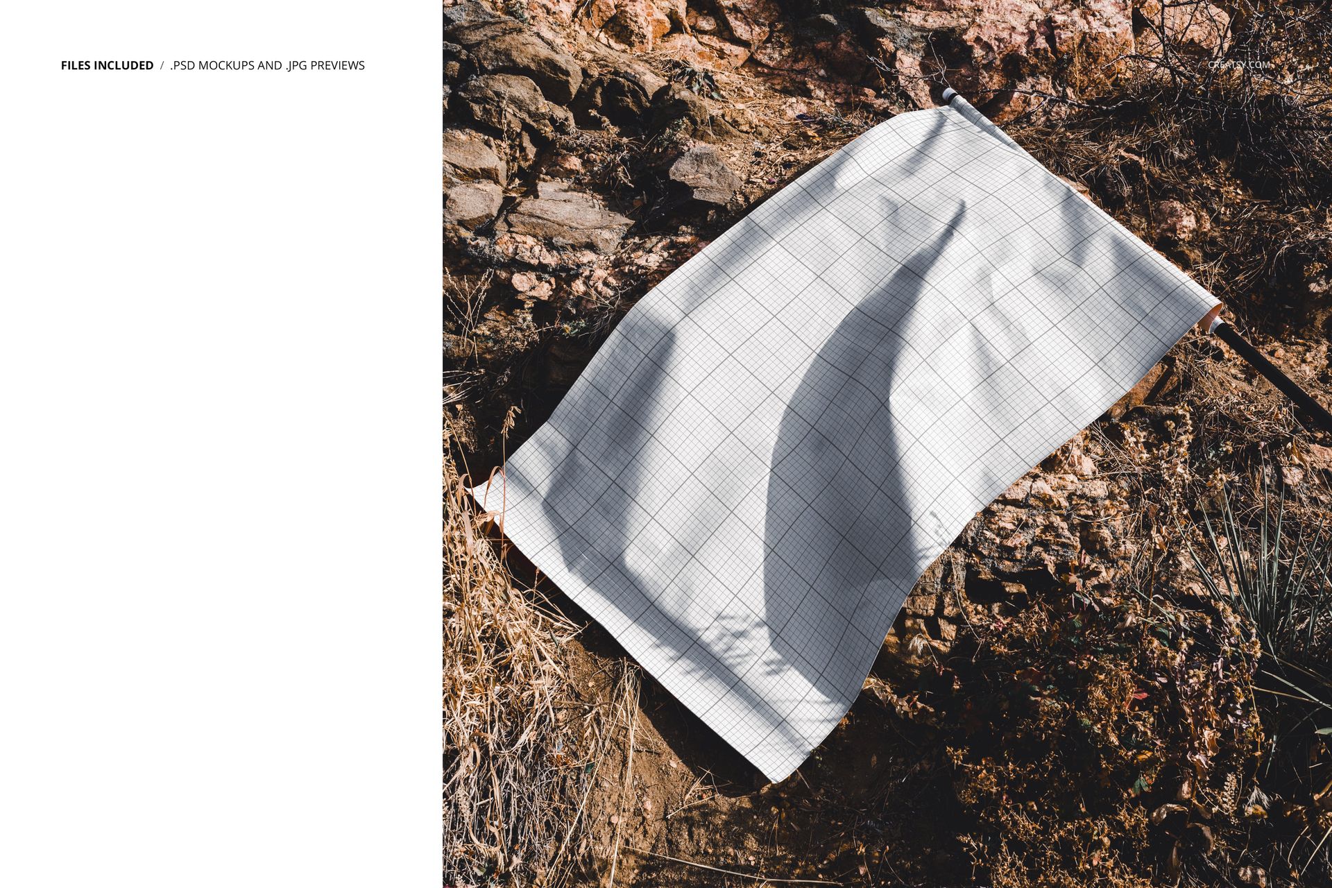 Rectangular flag mockup with a blank grid pattern lying on rocky ground, viewed from an angled top perspective.