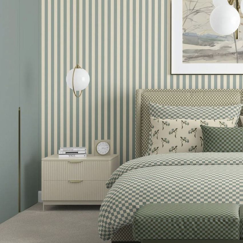 Bedroom scene bedding mockup featuring a bed with checkered and floral patterned linens, striped wallpaper, and a modern nightstand.