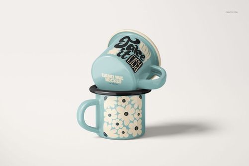 Two light blue enamel mugs stacked together, one featuring floral patterns and the other with bold text, on a plain background.