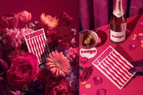 PSD mockup featuring a Valentine's Day card surrounded by vibrant flowers and set on a red surface with festive props.