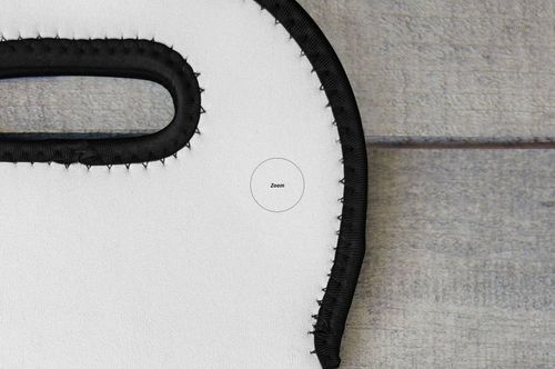 Detailed section of a wine bag mockup showing black trim and handle against a textured gray wood background.