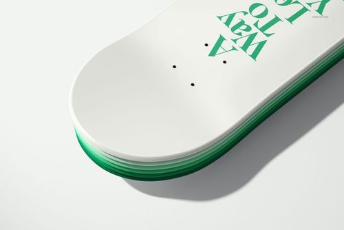 Front angled view of a skateboard deck mockup showing white top, green sides, and bold green lettering.