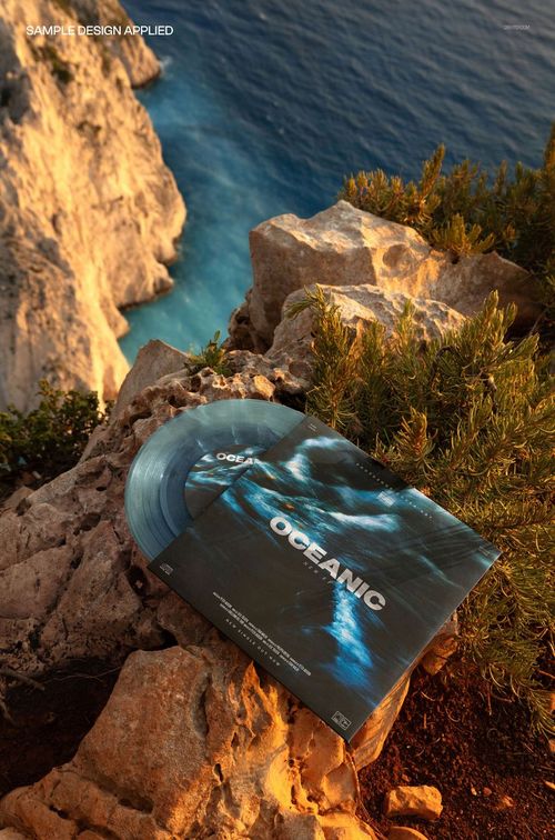 Translucent vinyl record and matching album cover mockup set on rocky outdoor cliff with ocean in the background.