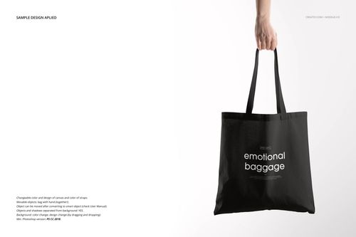 Front view of a black tote bag mockup held by a hand, featuring white text design in a minimalist setting.
