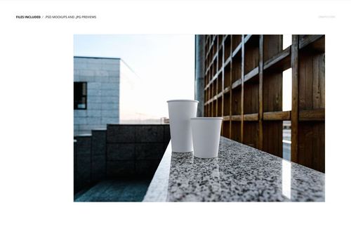 PSD mockup showing two simple paper cups on a marble ledge, set against contemporary cityscape and architectural elements.