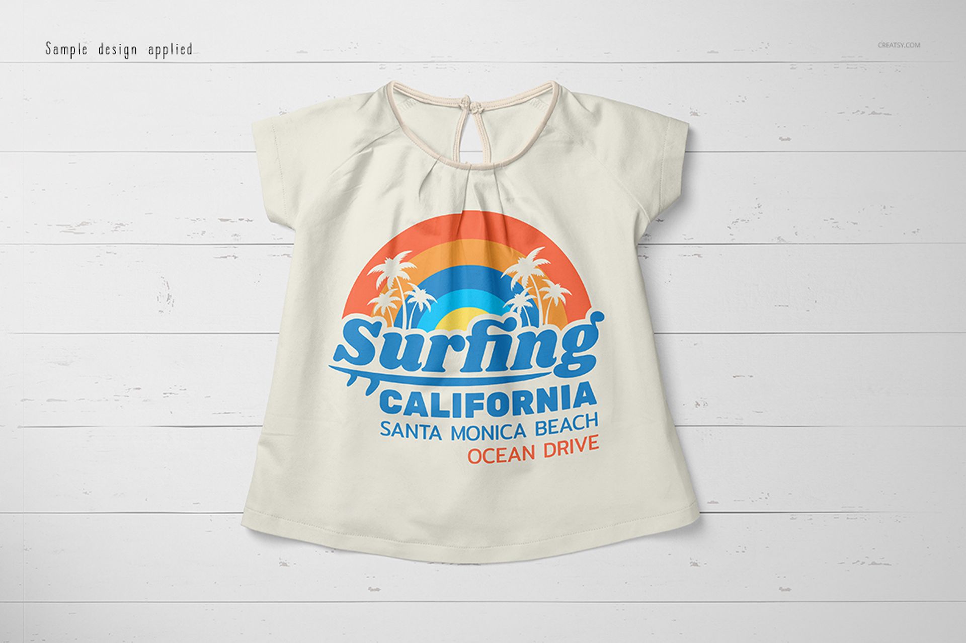 Front view of a baby summer shirt mockup with short sleeves, displayed on a white wooden surface, featuring a colorful print.