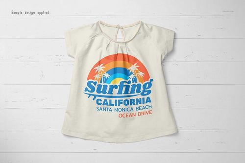 Front view of a baby summer shirt mockup with short sleeves, displayed on a white wooden surface, featuring a colorful print.