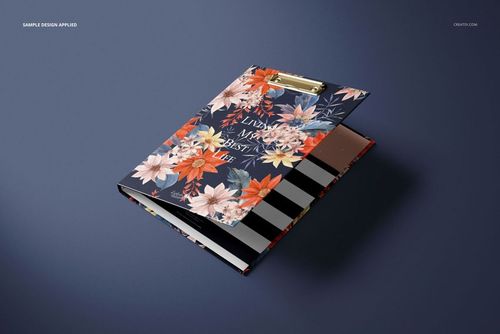 Front view of a floral patterned clipboard folder with gold clip, placed on a dark surface, mockup style.