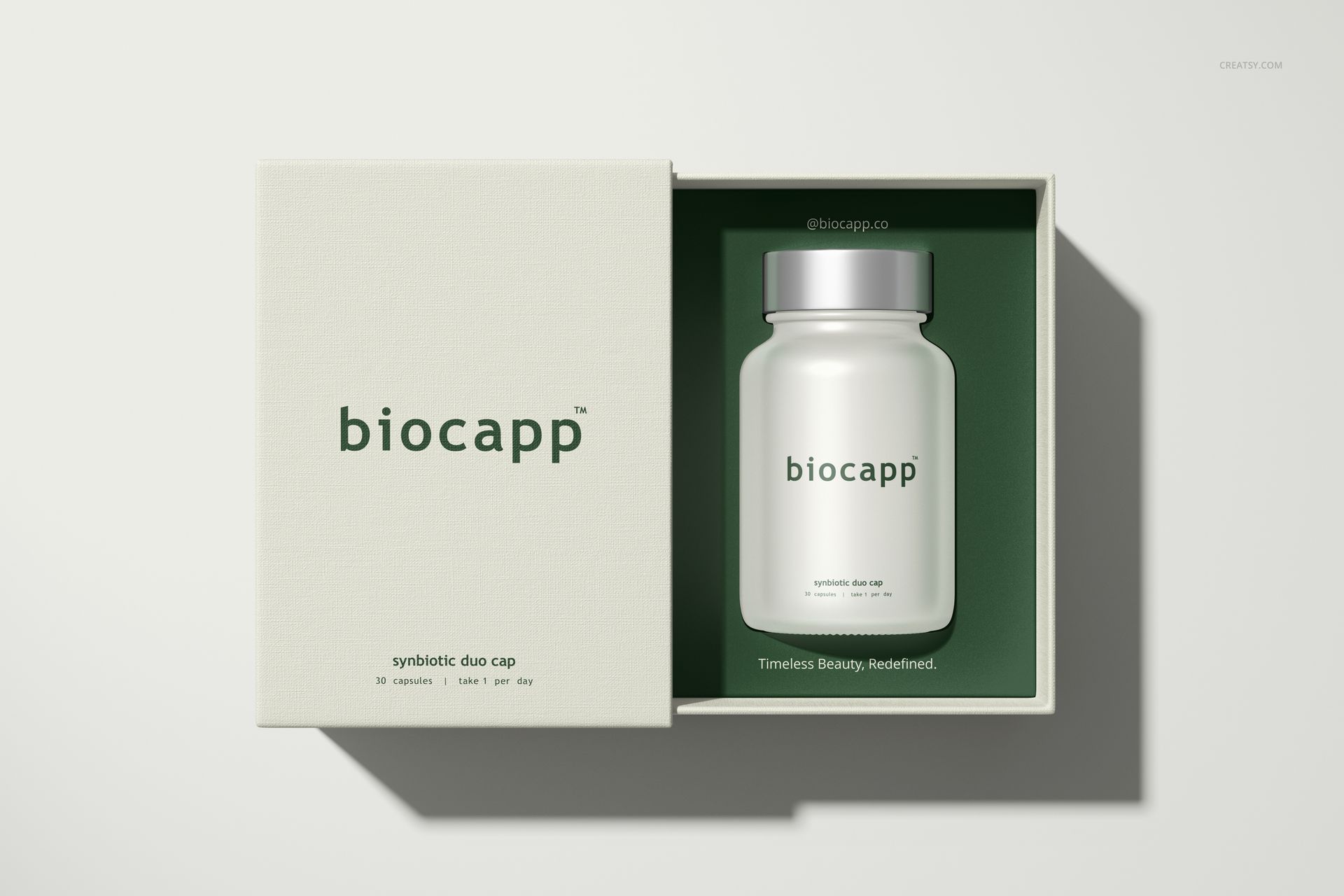Front view of a cosmetics box packaging mockup with an open lid, revealing a frosted bottle inside on a green base.