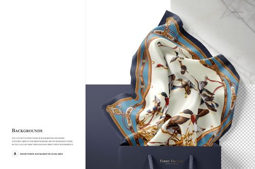 Elegant silk scarf featuring a decorative bird motif and ornate borders, displayed inside a navy blue bag, PSD mockup.