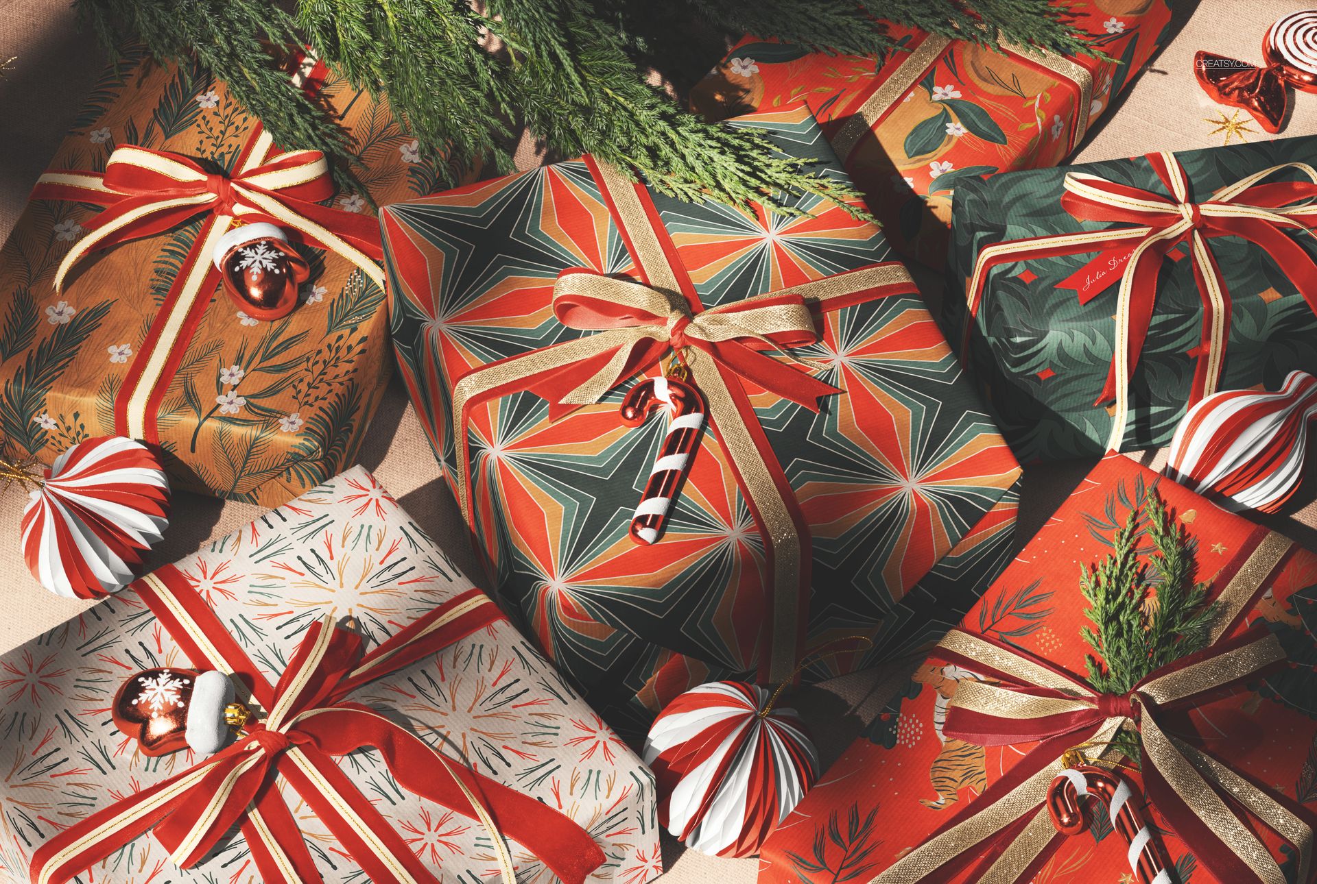 Christmas wrapped gift boxes with colorful geometric and festive patterns, viewed from above with ribbons and ornaments.