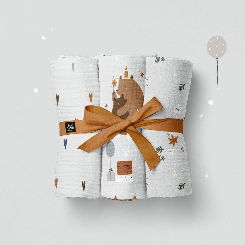 Crinkle muslin swaddle blanket mockup featuring a folded white blanket with playful animal and star patterns, tied with a brown ribbon.