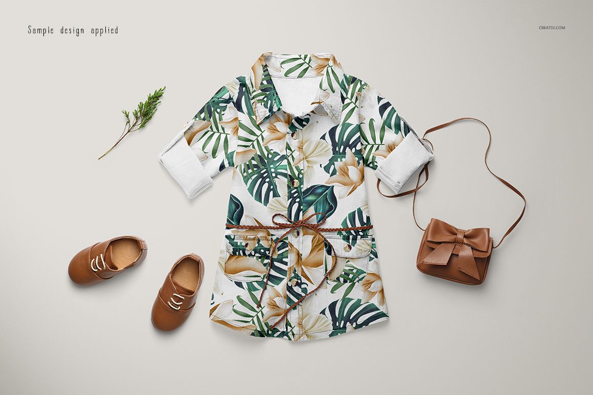 Baby jeans dress mockup with green and beige botanical print, brown accessories, and flat lay arrangement.