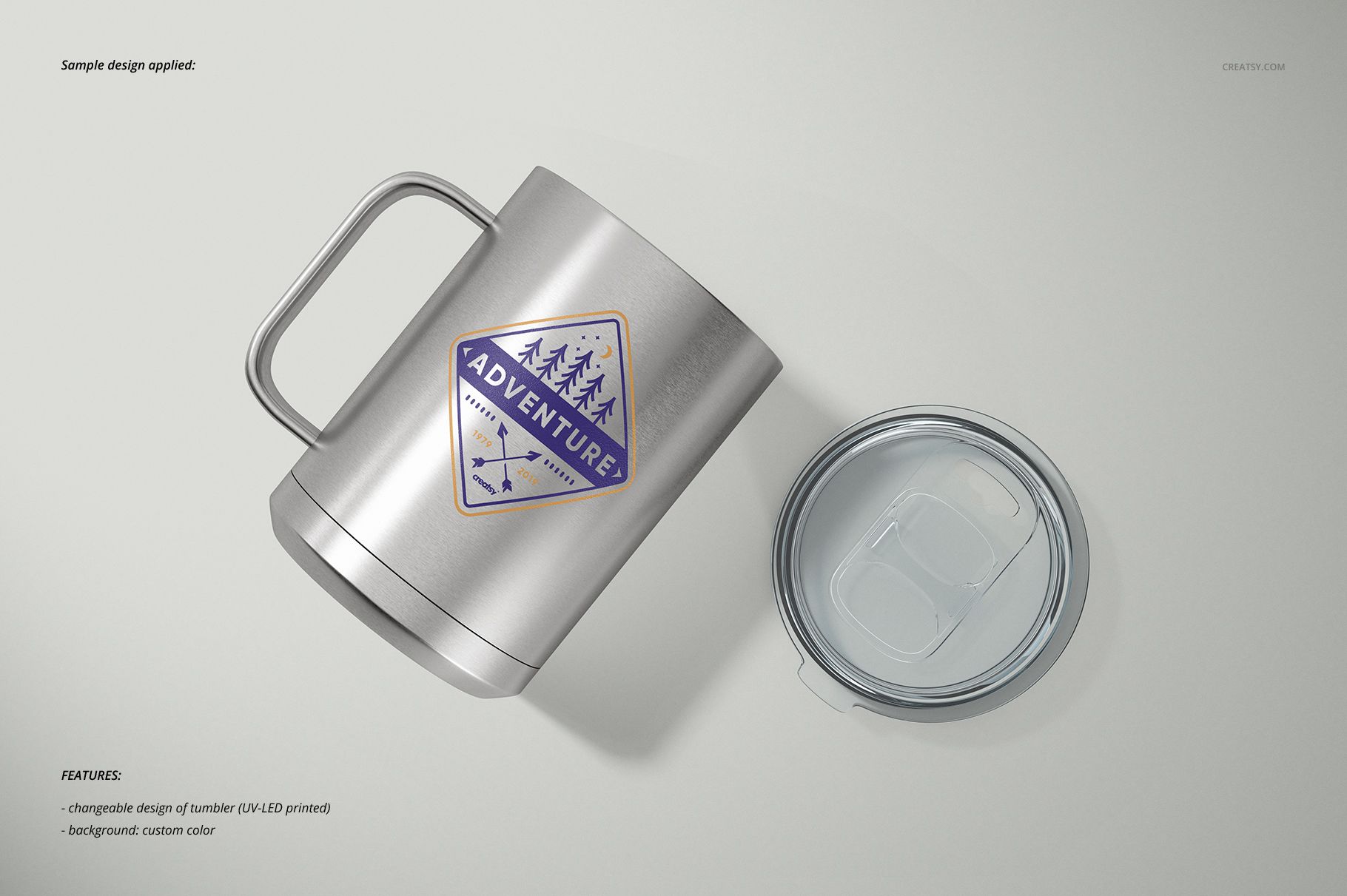 Stainless steel camp coffee mug with handle and removable clear lid, shown on a light background, front and top view.