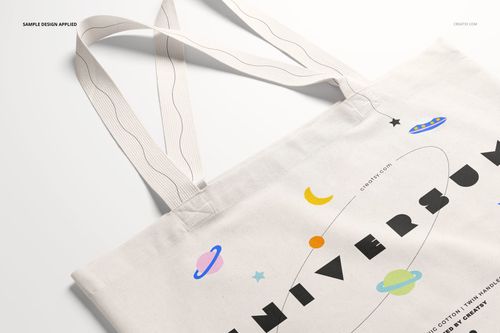 Front angled view of a weekender tote bag mockup with long handles, featuring a space-themed design on light fabric.